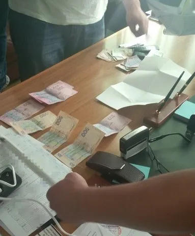 На хабарі зловили двох посадовців сервісного центру МВС (фото)