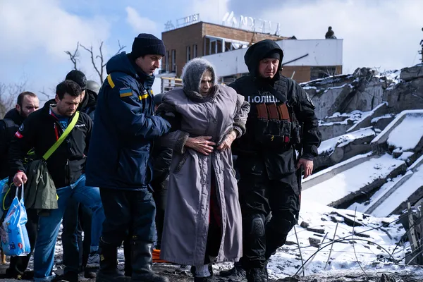 Працівник ДСНС та поліції допомагають літній жінці евакуюватись з міста Ірпінь