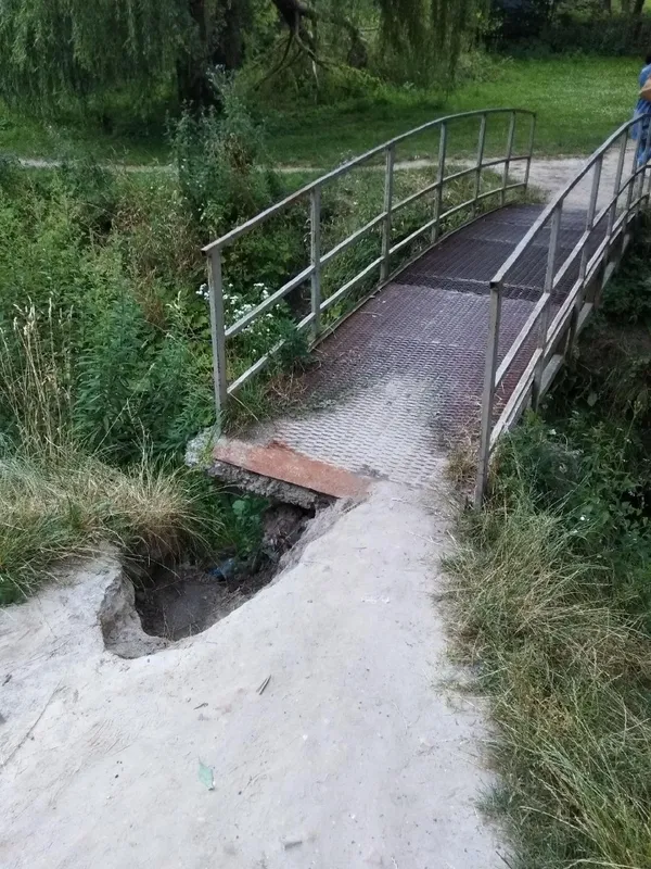Величезна яма: у Луцьку просять відремонтувати аварійний міст у парку (фото)