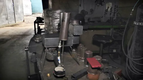 Сконструйована мінібуржуйка, через корпус якої наливають зверху машинне мастило