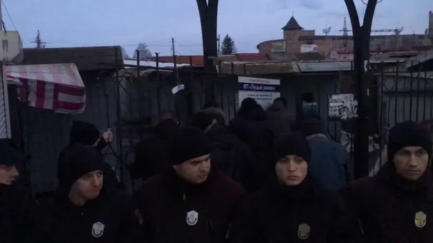 Знову сутички: муніципали зрізають «болгарками» паркан навколо ринку. Базарники перешкоджають (відео)