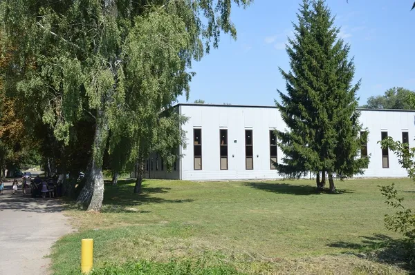 Біле приміщення - це церква. На території біля неї можливо буде парковка