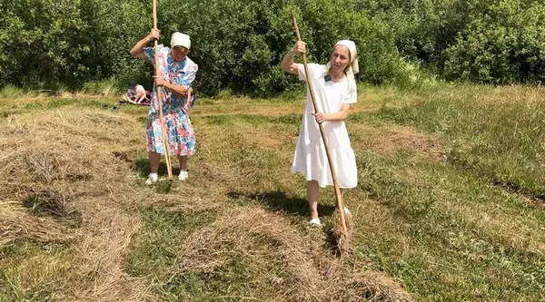 Галина Василюк (справа) з мамою гребе сіно дерев’яними граблями