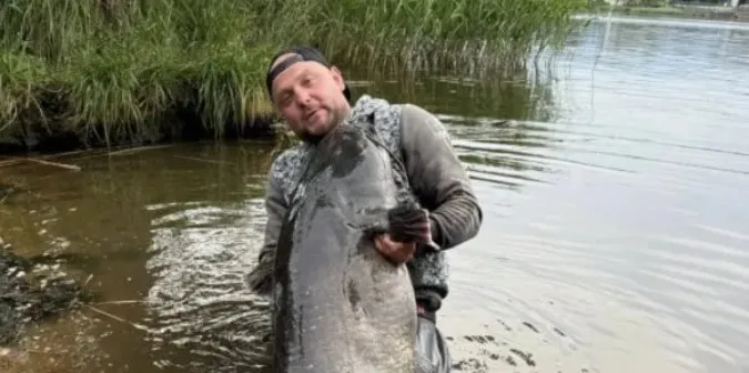 У Польщі чоловік упіймав сома, що важить як доросла людина