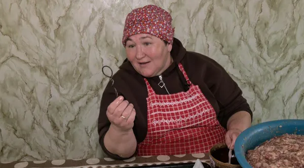 Оксана Лойко показує кільце, яке використовувала для начинювання кишки фаршем