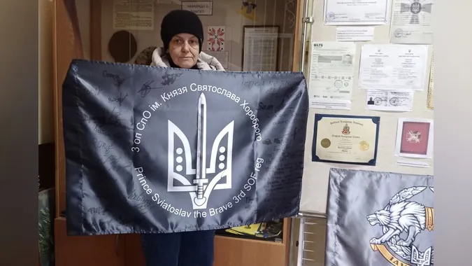 Мама загиблого воїна передала ковельському музею прапор з підписами побратимів, яких він врятував