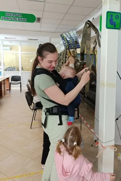 Поки очікують в черзі: у Луцькому ЦНАПі відвідувачі плетуть маскувальні сітки (фото)