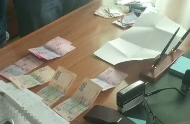 На хабарі зловили двох посадовців сервісного центру МВС (фото)