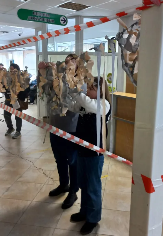Поки очікують в черзі: у Луцькому ЦНАПі відвідувачі плетуть маскувальні сітки (фото)