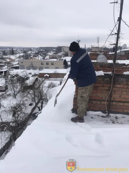 Без страховки: волинський комунальник заліз на небезпечний дах, щоб прибрати сніг (фото)