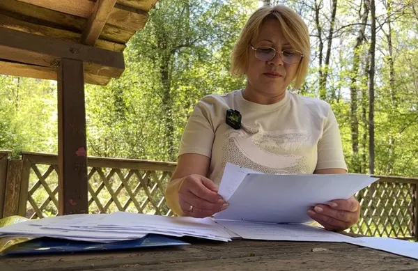 Тетяна Орищук показує стос документів, які зібрала після зникнення брата