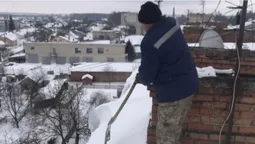 Без страховки: волинський комунальник заліз на небезпечний дах, щоб прибрати сніг (фото)