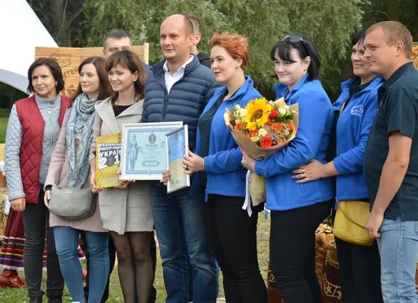Голова правління «Теремно хліб» Андрій Тищенко з командою отримали нагороду за гігантський коровай. З квітами - директор департаменту виробництва «Теремно хліб» Інна Іпатюк  