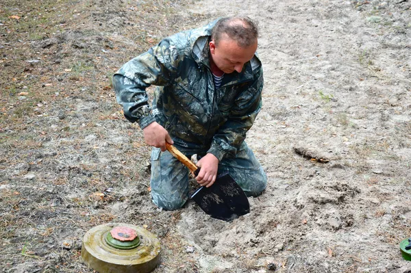 Один з добровольців демонструє, як потрібно встановлювати протитанкову міну...