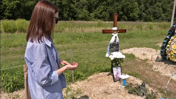 Донька військового Юрія Торбича Інна поруч із його могилою на кладовищі в Ківерцях